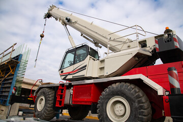 Truck crane with a raised boom with a hook on the construction site of a road bridge