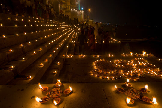 People gather at the ghats in Varanasi for Dev Deepawali with candles lit at night in celebration of the the festival of Kartik Poornima; Varanasi, India