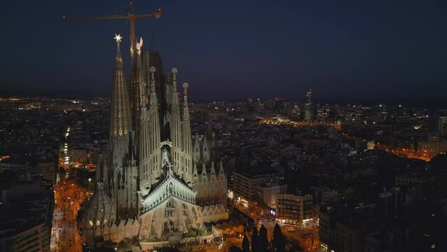 Evening flying counter clockwise around Sagrada Familia Cathedral in Barcelona
