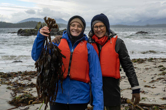 Mother and daughter enjoying nature while hiking along the rugged coastline at Brady's Beach in Bamfield on Vancouver Island; Bamfield, British Columbia, Canada