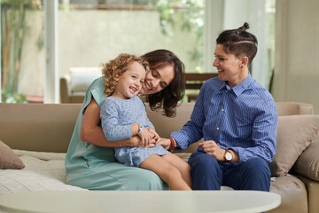 Lesbian couple enjoying spending time with their little daughter