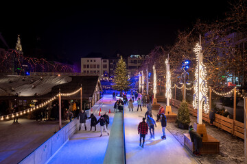 Top night view over temporary ice rink with people enjoy ice skating at Heumarkt, famous Christmas...