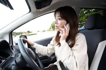 車内で電話をする若いアジア人女性
