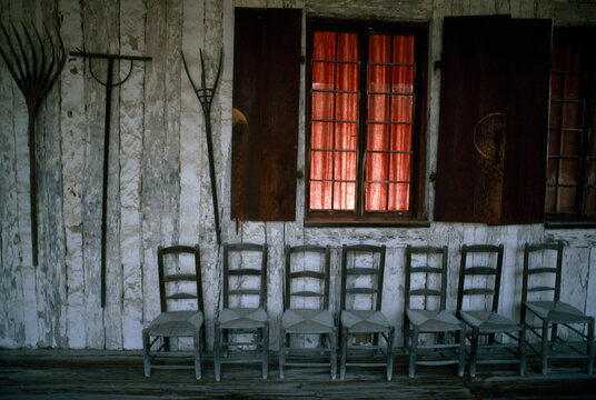 Porch of the Bolduc House Museum with antique chairs and rakes on display; Sainte Genevieve, Missouri, United States of America