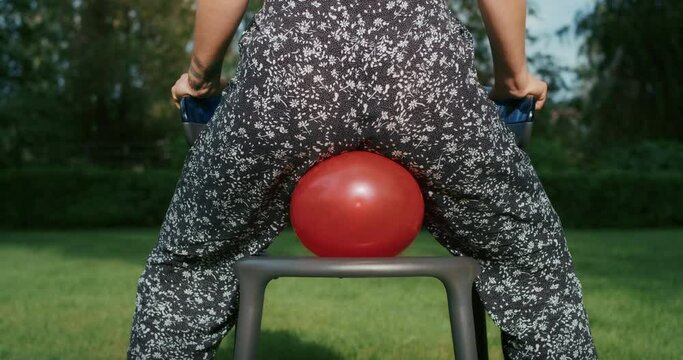 a joyful woman plays with balloons, imitating the reliability of condoms during sex, they will withstand any test and load.