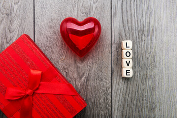 Red heart, inscription from wooden cubes LOVE and a gift in a box. concept for Valentine's day.
