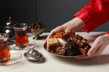 Woman serving Turkish delight on vintage tray, closeup