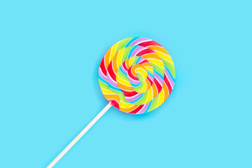 Rainbow lollipop on blue background.