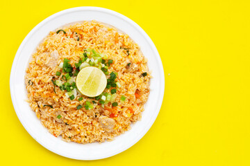 Fried rice in white plate on yellow background.