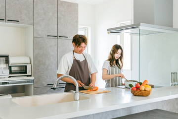 家のキッチンで一緒に料理を作る若いアジア人夫婦（家事メン）
