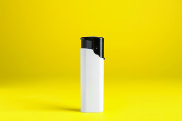 Stylish small pocket lighter on yellow background