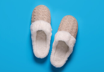 Pair of beautiful soft slippers on light blue background, top view