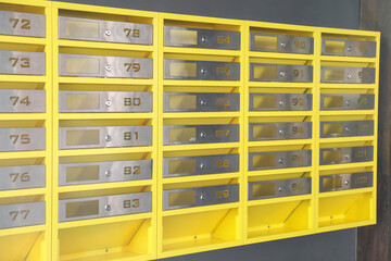 Many closed metal mailboxes with keyholes and numbers in post office