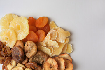 Pile of different dried fruits on white background, top view. Space for text