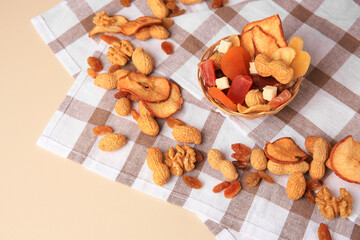 Mixed dried fruits and nuts on beige background, above view