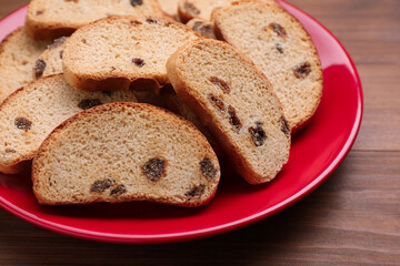 Plate of sweet hard chuck crackers with raisins on wooden table, closeup