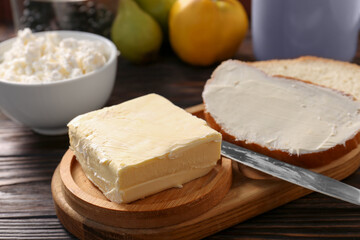 Tasty homemade butter, bread slices and tea on wooden table, closeup