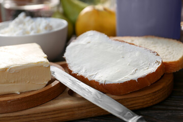 Tasty homemade butter, bread slices and tea on wooden table, closeup