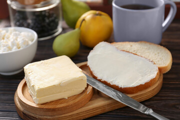 Tasty homemade butter, bread slices and tea on wooden table