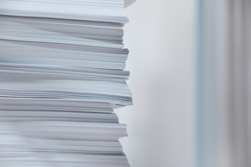 Stack of paper sheets against blurred background, closeup. Space for text