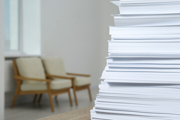 Stack of paper sheets on wooden table indoors, closeup. Space for text