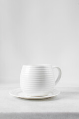 white ceramic cup on a white  saucer, white teacup