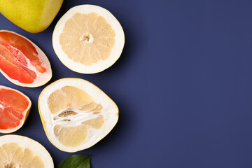 Different sorts of tasty pomelo fruits on dark blue background, flat lay. Space for text