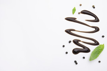 Organic balsamic vinegar, peppercorns and basil leaves on white background, flat lay. Space for text