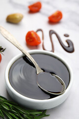 Organic balsamic vinegar and cooking ingredients on white marble table, closeup