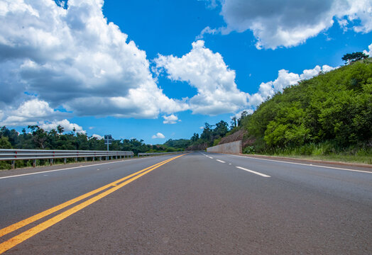 Carretera con una vista de paisajes verdes con el cielo azul 