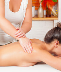 Obraz na płótnie Canvas Girl getting back massage in massage salon, health spa from a woman massage therapist 