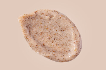 Scrub smear swatch isolated on beige background. Peeling cream smudge with exfoliating particles. Cosmetic skincare product with abrasive particle sample, gentle nude scrub texture isolate.