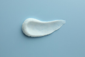 Sample of face scrub on light blue background, top view