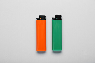 Stylish small pocket lighters on white background, flat lay