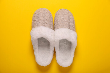 Pair of beautiful soft slippers on yellow background, top view