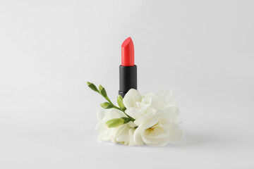 Obraz na płótnie Canvas Beautiful lipstick and flowers on white background