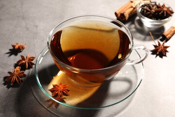 Aromatic tea with anise stars on light grey table