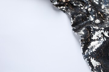 Beautiful bright sequin fabric on white background, above view. Space for text