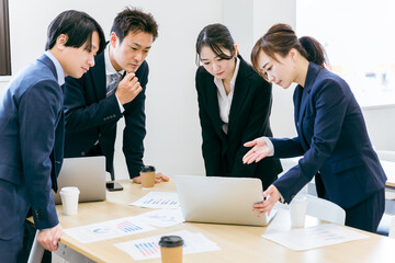 会社のデータを見ながら真剣に話し合うビジネスマンとビジネスウーマン（トラブル）
