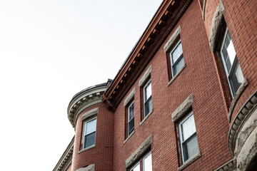 Oblique view of brick apartment building with rusticated stone window lintels  and dentil trim...