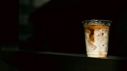 ice latte coffee in plastic glass on black table at cafe​