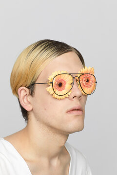 Portrait of handsome male model with gerbera flowers instead of eyes