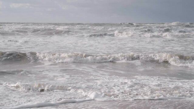Cinematic shot of waves breaking on a stormy day in the North Sea - Belgium