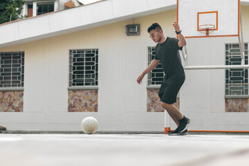 young man kicking a soccer ball