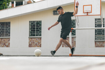 Fototapeta na wymiar young man kicking a soccer ball