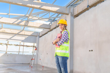 Side view of female engineer using walkie-talkie in construction site for building site survey in civil engineering project.