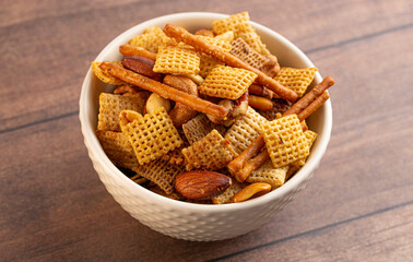 Bowl of Homemade Cereal Nut and Prezel Trail Mix on a Wooden Table