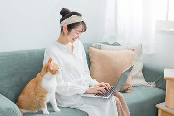 家で猫と一緒にテレワーク・リモートワークする女性
