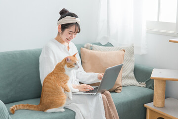 家で猫と一緒にテレワーク・リモートワークする女性
