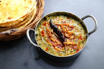 Sarson ka saag and Makke di roti. mustard leaves curry. It's a popular Punjabi winter dish made using corn meal and mustard leaves. served with onions and green chili. with copy space.